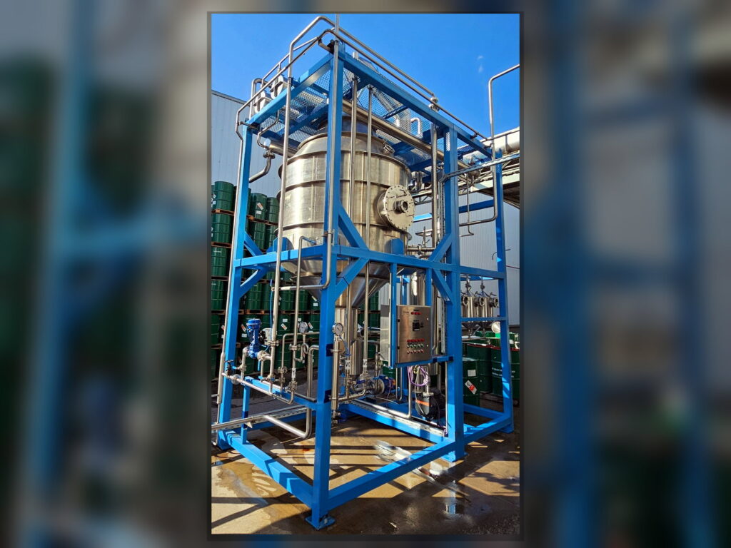 Compact FPM GLOBAL distillation unit with stainless steel vessel, process piping and control panel.