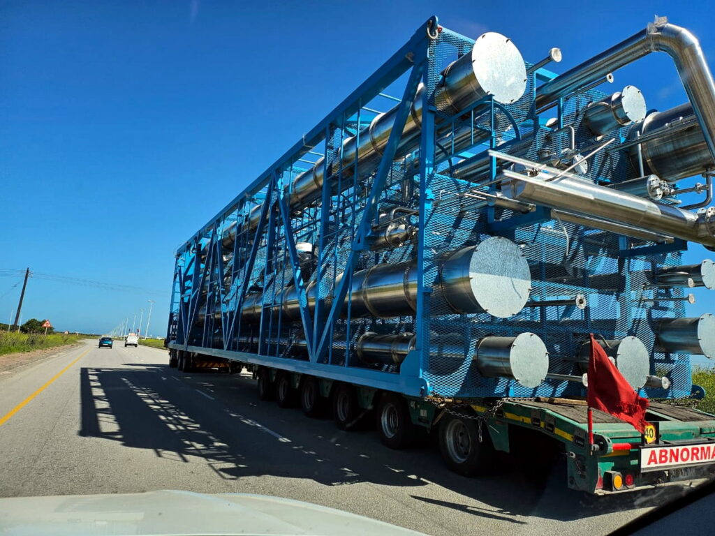 Large FPM GLOBAL process equipment module transported by specialized heavy-haul trailer.